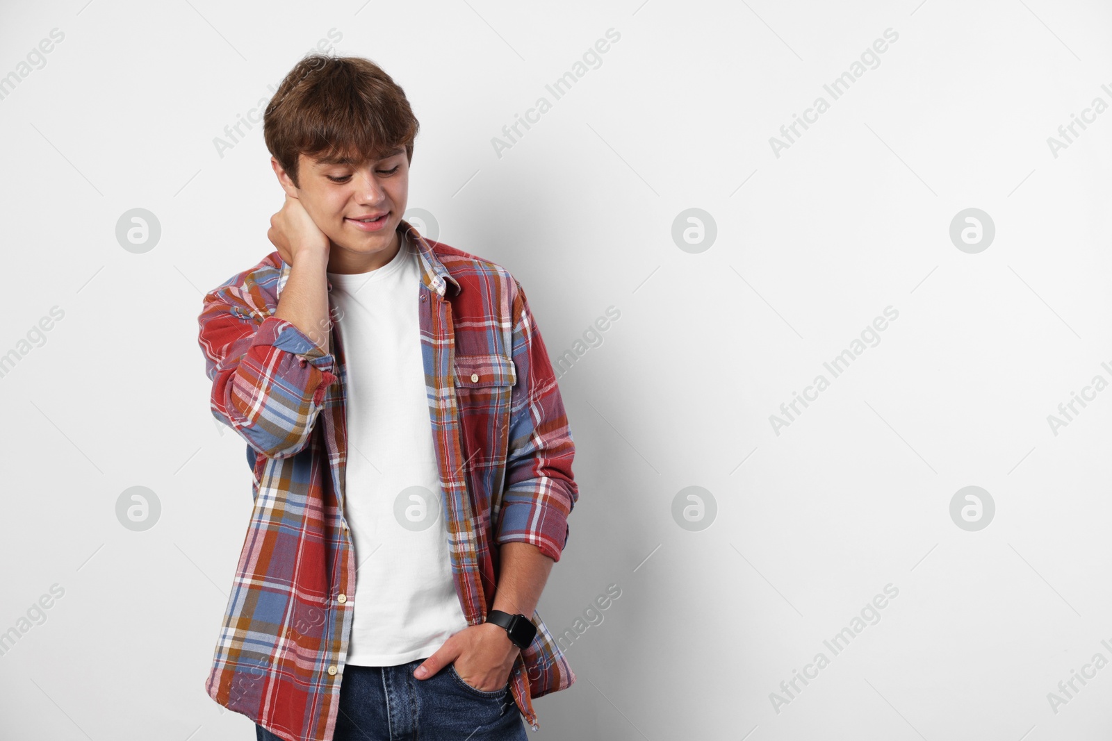 Photo of Smiling teenage boy on light grey background. Space for text