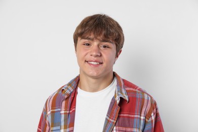 Photo of Portrait of smiling teenage boy on light grey background