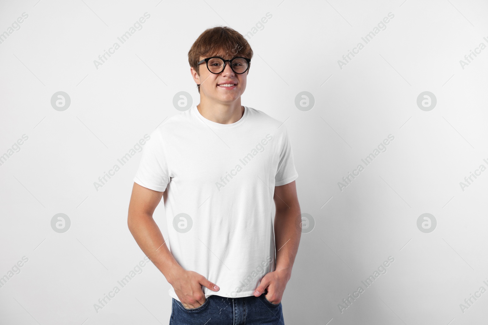 Portrait of smiling teenage boy in glasses on light grey background Photo of Portrait of smiling teenage boy in glasses on light grey background