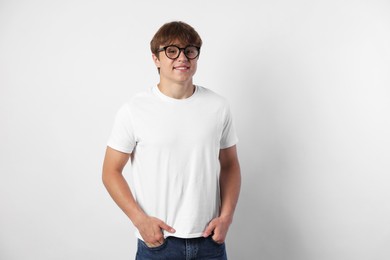 Photo of Portrait of smiling teenage boy in glasses on light grey background