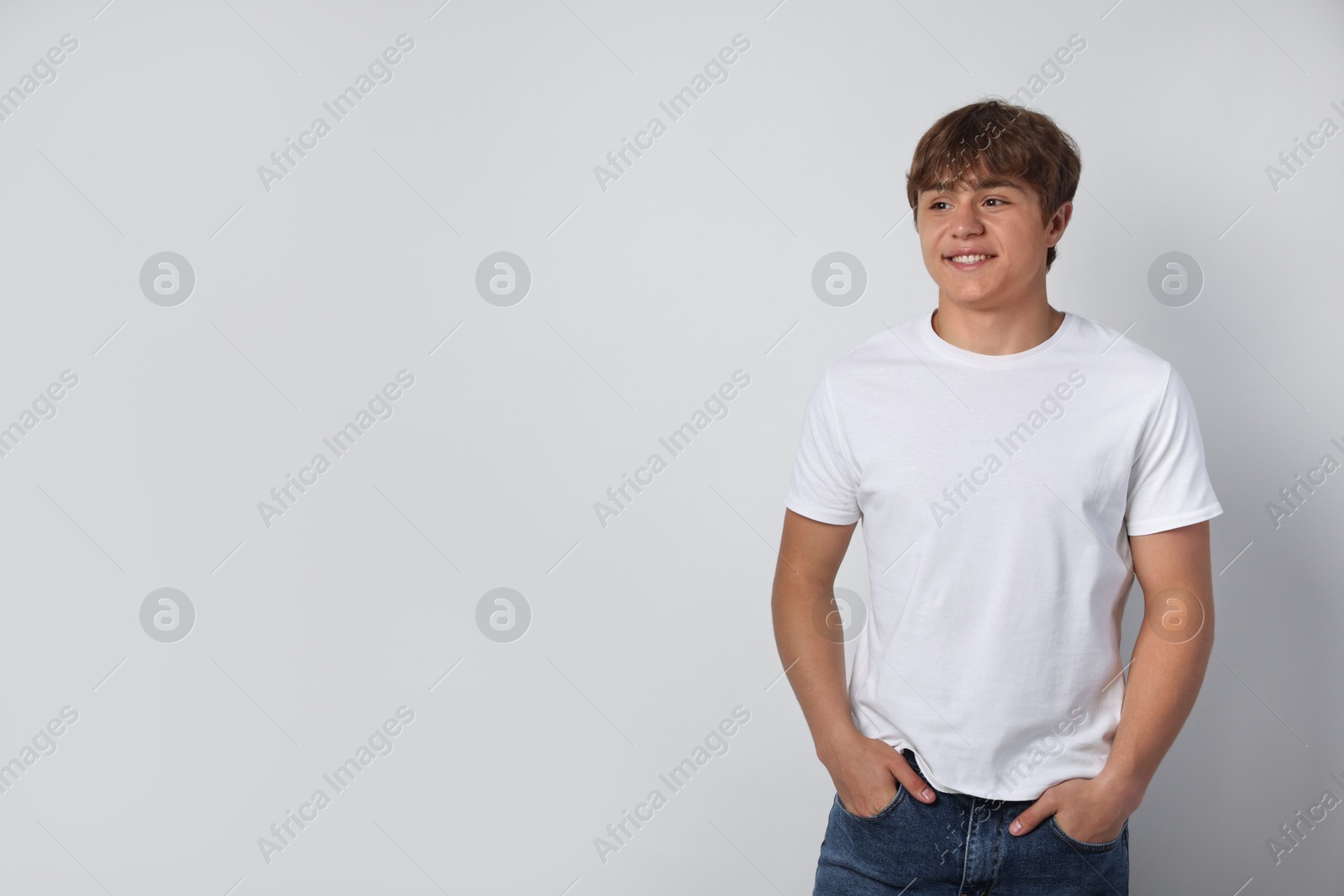 Smiling teenage boy on light grey background. Space for text Photo of Smiling teenage boy on light grey background. Space for text