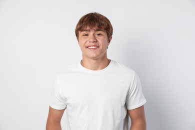 Photo of Portrait of smiling teenage boy on light grey background