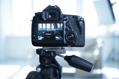 Photo of Shooting sofa with professional photo camera in studio, selective focus