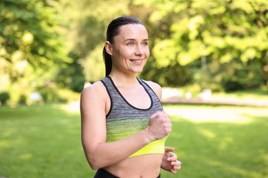 Photo of Sporty woman running in park. Healthy lifestyle