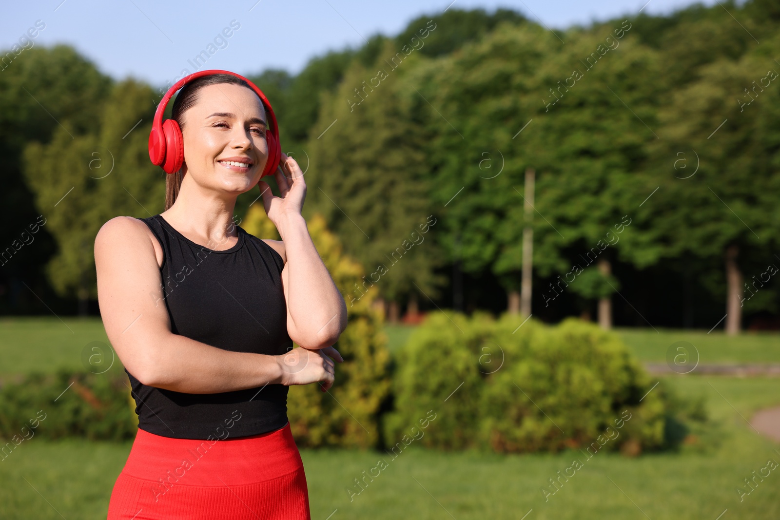 Photo of Happy woman in headphones outdoors, space for text. Healthy lifestyle