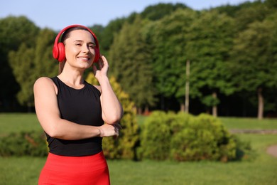 Photo of Happy woman in headphones outdoors, space for text. Healthy lifestyle