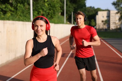 Photo of Sporty couple running at stadium. Healthy lifestyle