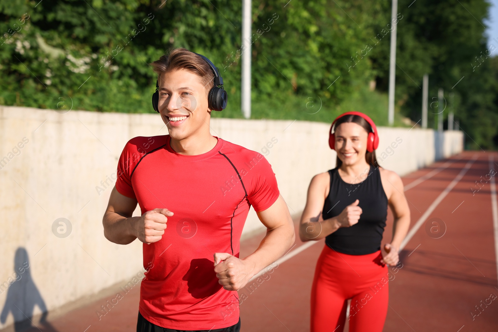Sporty couple running at stadium, selective focus Photo of Sporty couple running at stadium, selective focus