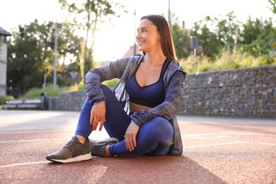 Photo of Happy woman in sportswear at stadium. Healthy lifestyle