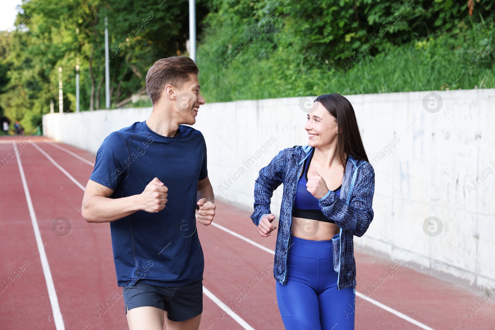 Photo of Sporty couple running at stadium. Healthy lifestyle