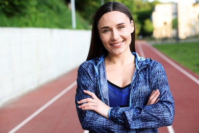 Photo of Happy woman in sportswear at stadium, space for text