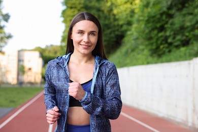 Photo of Sporty woman running at stadium. Healthy lifestyle