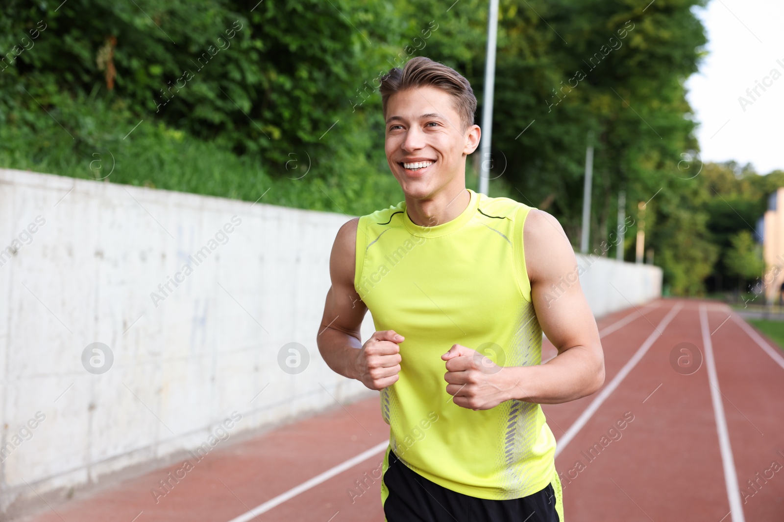 Photo of Sporty man running at stadium. Healthy lifestyle