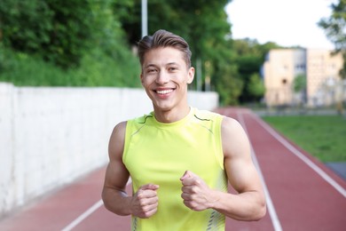 Photo of Sporty man running at stadium. Healthy lifestyle