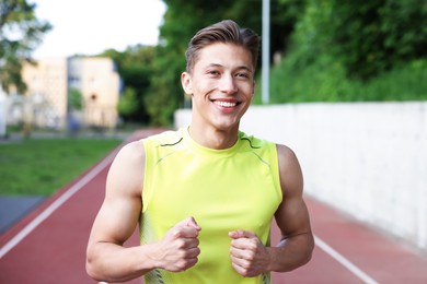 Photo of Sporty man running at stadium. Healthy lifestyle