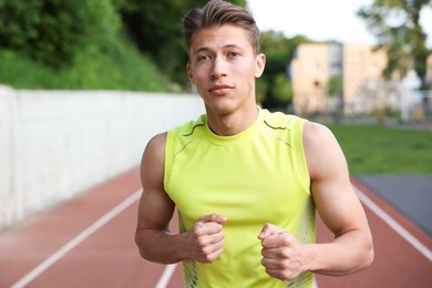 Photo of Sporty man running at stadium, space for text. Healthy lifestyle