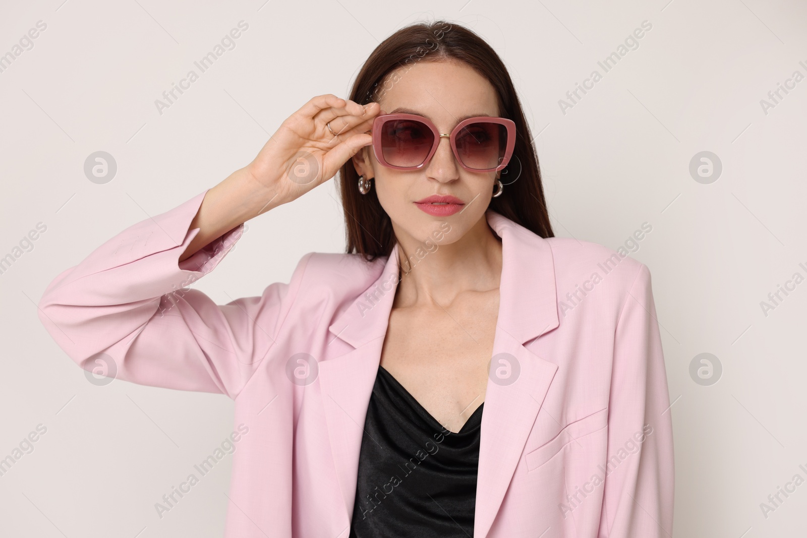 Photo of Portrait of beautiful woman in stylish outfit on white background