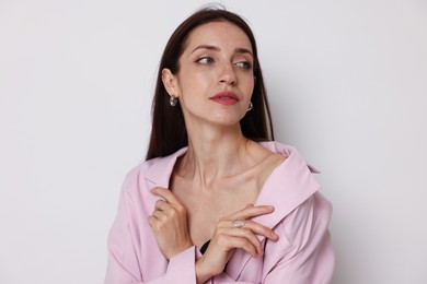 Photo of Portrait of beautiful woman in stylish outfit on white background