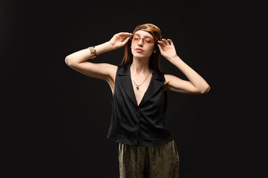 Photo of Portrait of beautiful woman in stylish outfit on black background