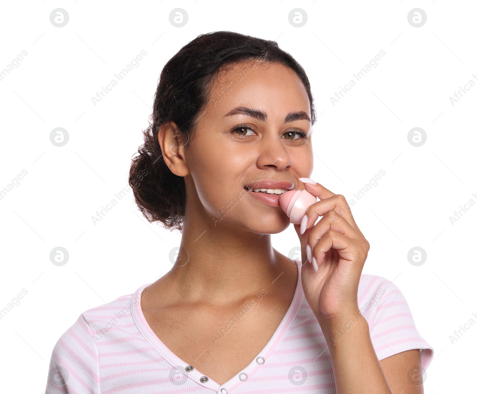 Photo of Smiling woman applying lip balm onto her lips on white background
