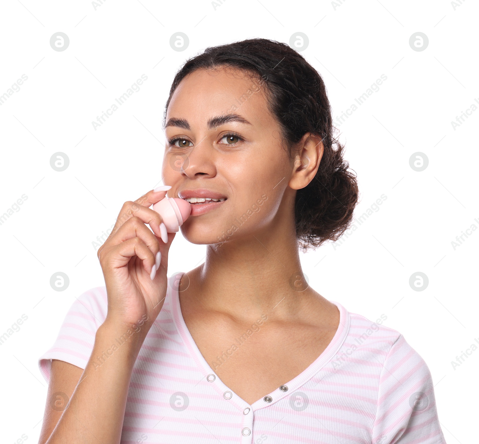 Photo of Smiling woman applying lip balm onto her lips on white background