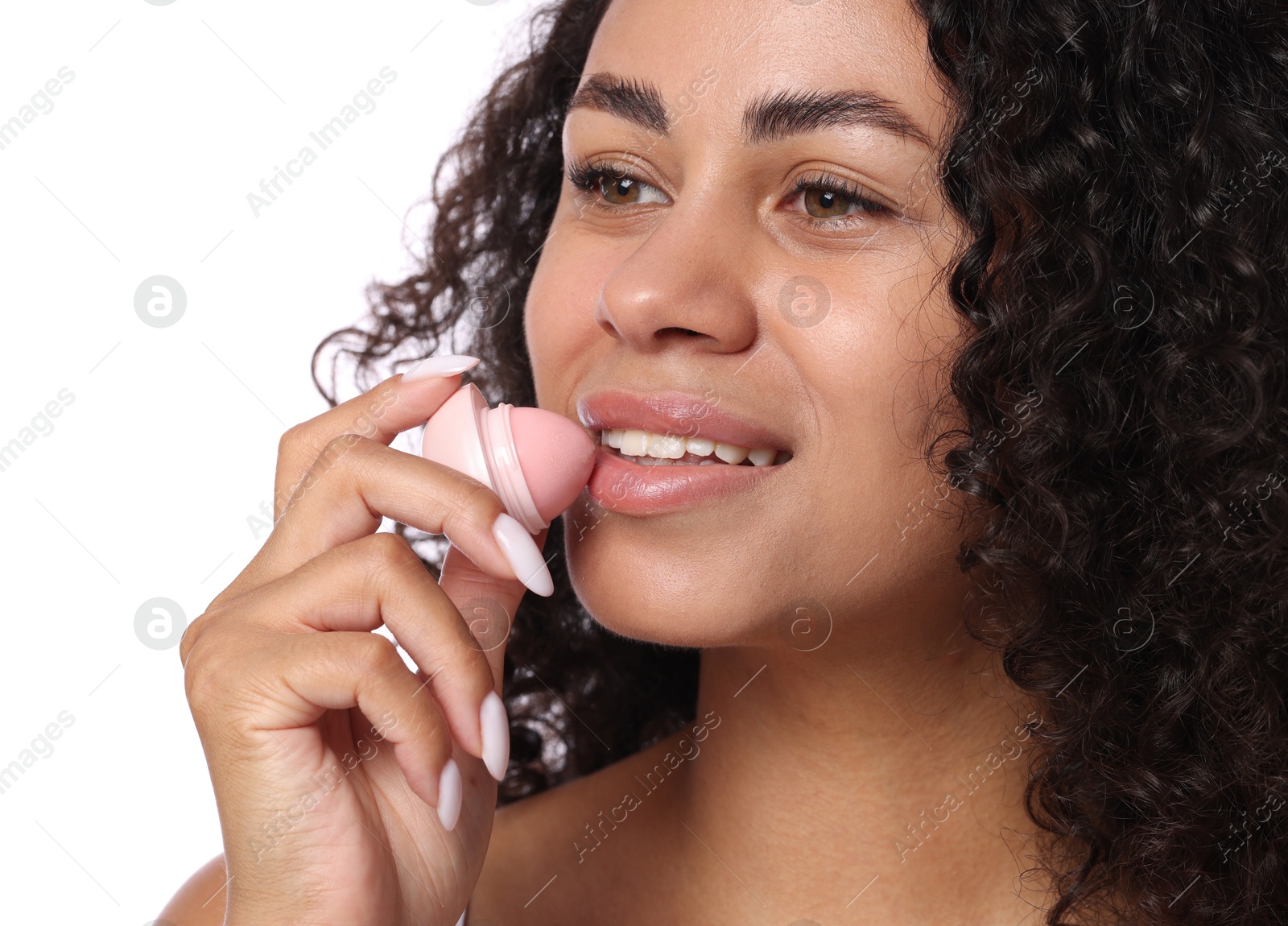 Photo of Smiling woman applying lip balm onto her lips on white background, closeup