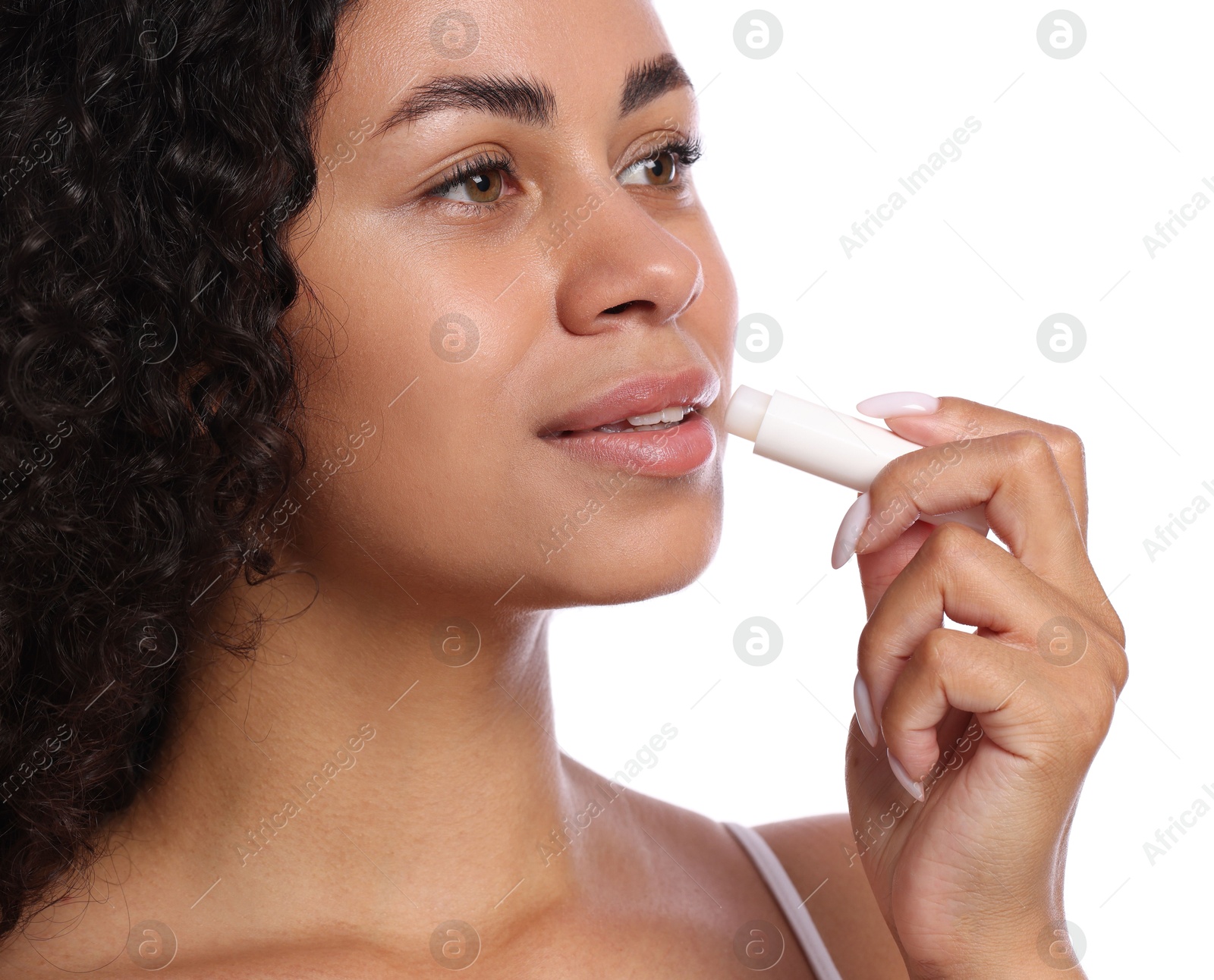 Photo of Beautiful woman applying lip balm onto her lips on white background, closeup