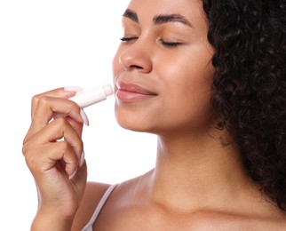 Photo of Beautiful woman applying lip balm onto her lips on white background, closeup