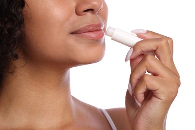Photo of Woman applying lip balm onto her lips on white background, closeup