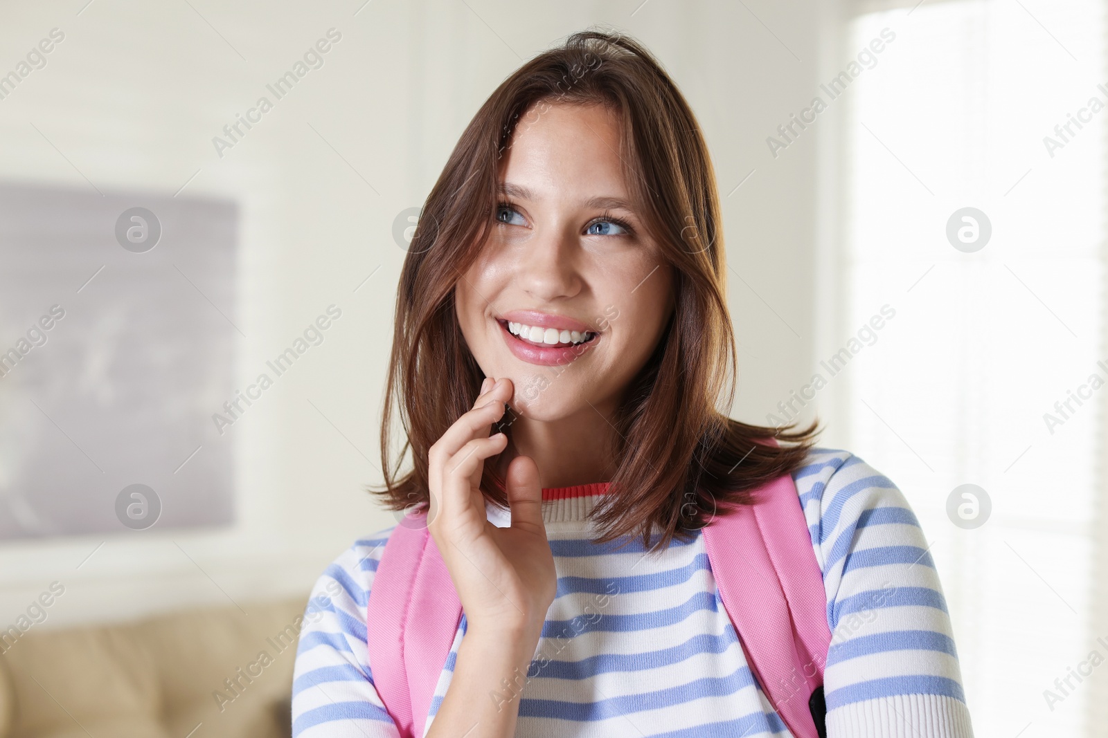 Smiling teenage girl with backpack at home Photo of Smiling teenage girl with backpack at home