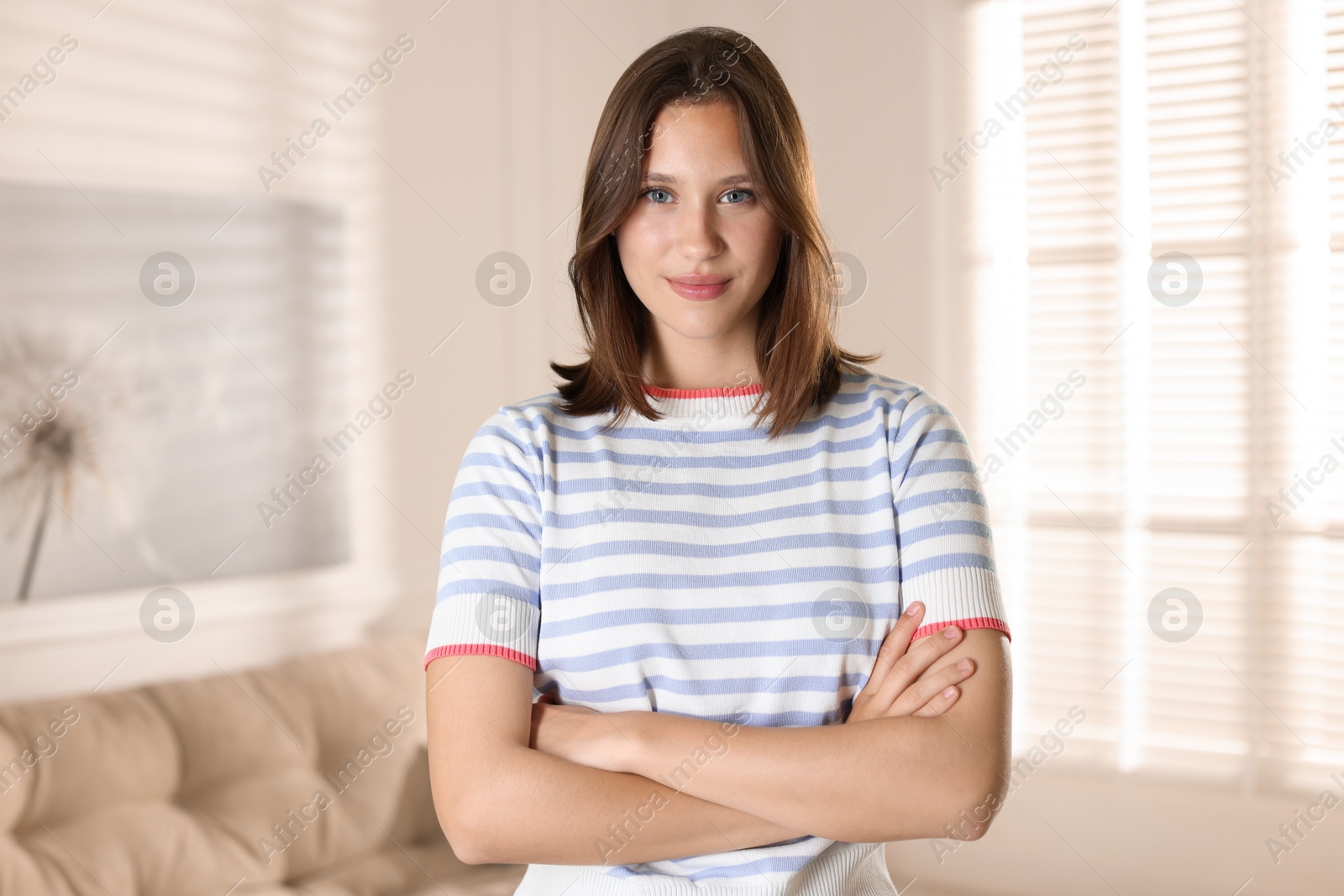 Portrait of beautiful teenage girl with crossed arms at home Photo of Portrait of beautiful teenage girl with crossed arms at home