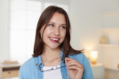 Photo of Smiling teenage girl with glasses at home