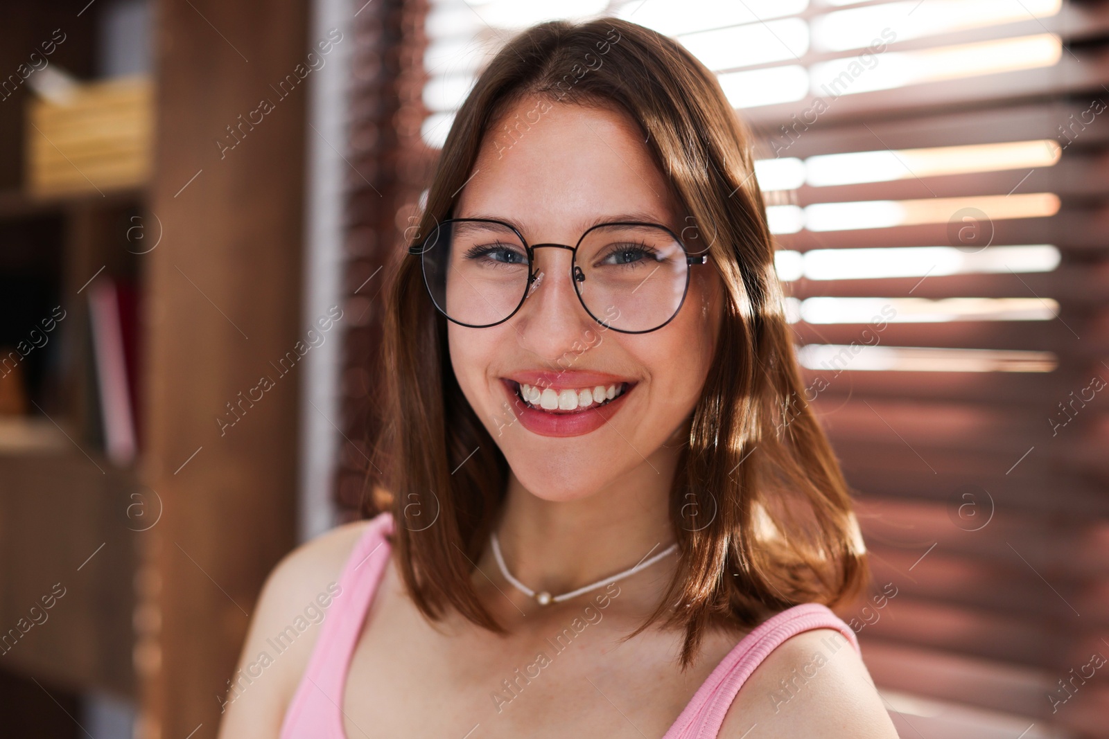 Portrait of smiling teenage girl in glasses at home Photo of Portrait of smiling teenage girl in glasses at home