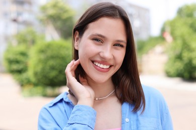 Photo of Portrait of smiling teenage girl on city street