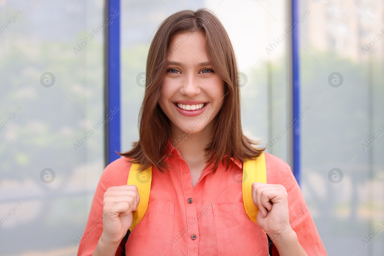 Portrait of smiling teenage girl near building outdoors Photo of Portrait of smiling teenage girl near building outdoors