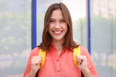 Photo of Portrait of smiling teenage girl near building outdoors