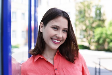 Photo of Portrait of smiling teenage girl near building outdoors