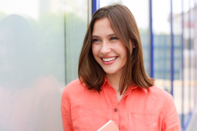 Photo of Portrait of smiling teenage girl near building outdoors