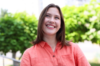 Photo of Portrait of smiling teenage girl on city street