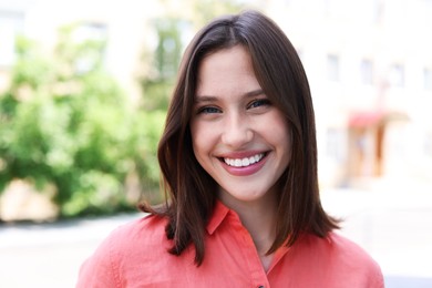 Photo of Portrait of smiling teenage girl on city street
