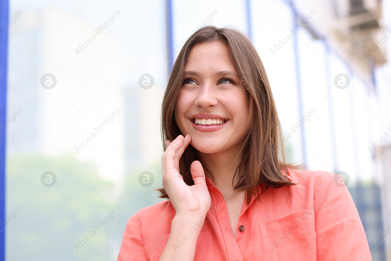 Portrait of smiling teenage girl near building outdoors Photo of Portrait of smiling teenage girl near building outdoors