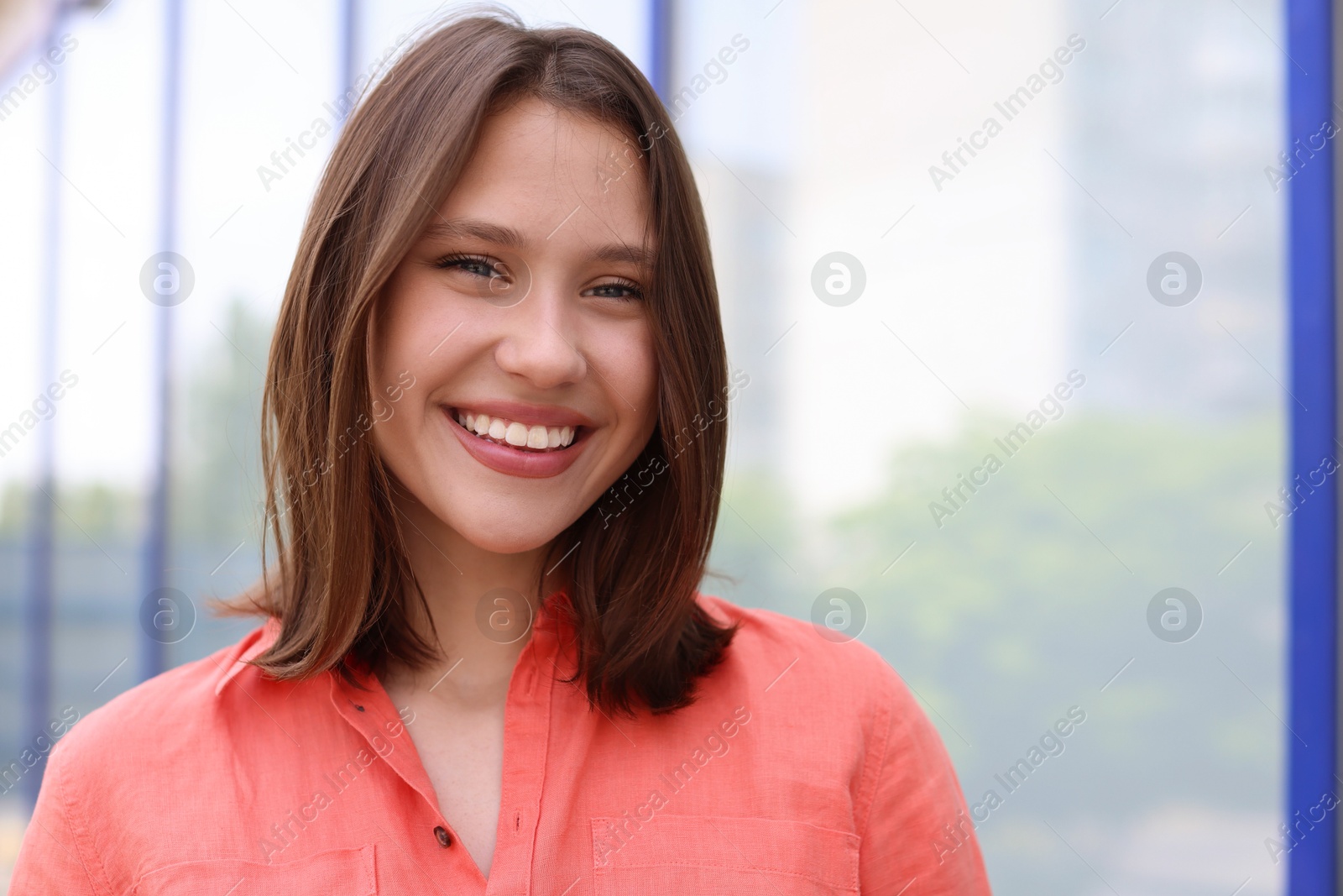 Portrait of smiling teenage girl near building outdoors Photo of Portrait of smiling teenage girl near building outdoors