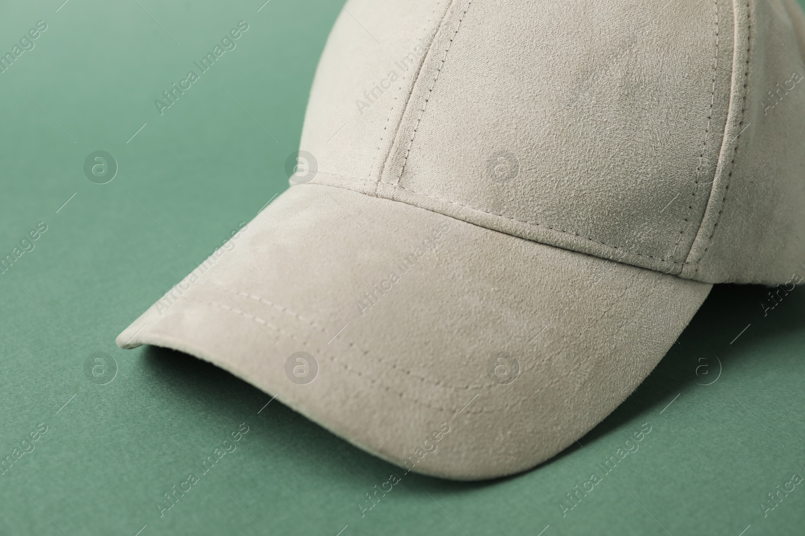 Beige baseball hat on green background, closeup. Mockup for design Photo of Beige baseball hat on green background, closeup. Mockup for design