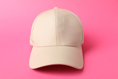 Photo of Beige baseball hat on pink background, closeup. Mockup for design