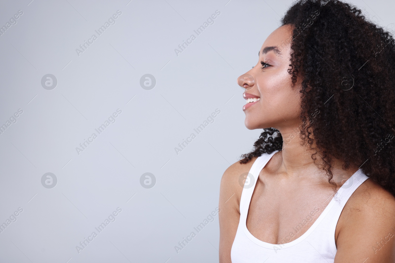 Photo of Beautiful Brazilian woman with healthy skin on gray background. Space for text