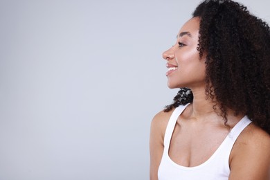 Photo of Beautiful Brazilian woman with healthy skin on gray background. Space for text