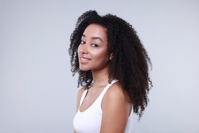Photo of Beautiful Brazilian woman with healthy skin on gray background