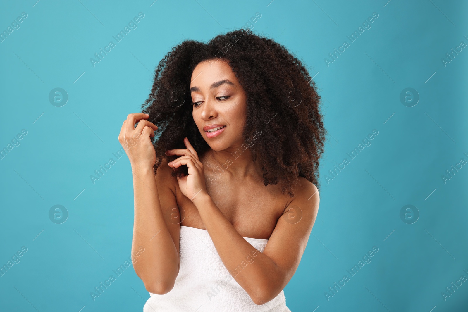 Photo of Portrait of beautiful Brazilian woman after spa treatment on light blue background