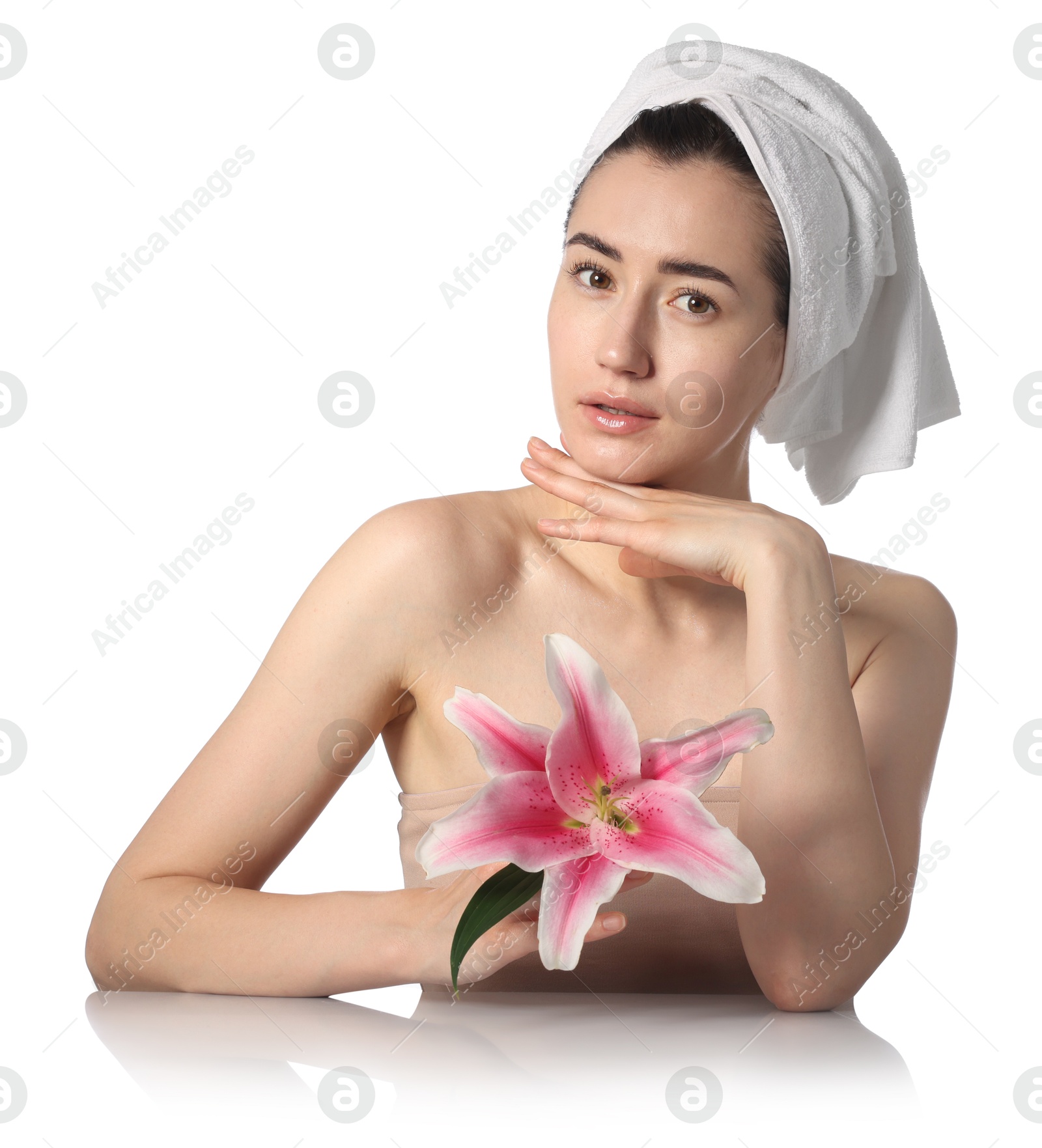 Photo of Portrait of beautiful woman with lily flower after spa treatment at mirror surface on white background