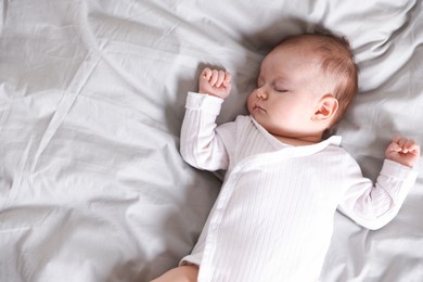 Photo of Cute newborn baby sleeping on bed, top view. Space for text